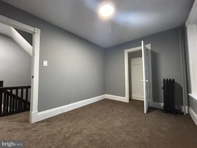 an empty room with windows and ceiling fan
