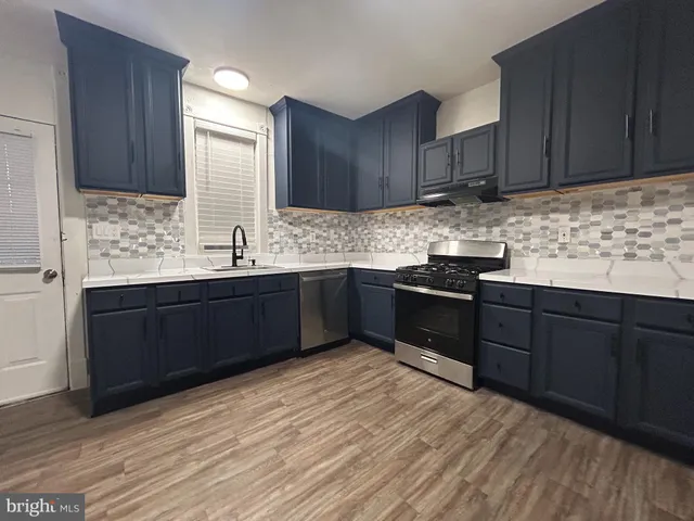 a kitchen with granite countertop stainless steel appliances and wooden cabinets