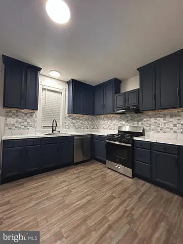 a kitchen with granite countertop wooden cabinets a sink and dishwasher
