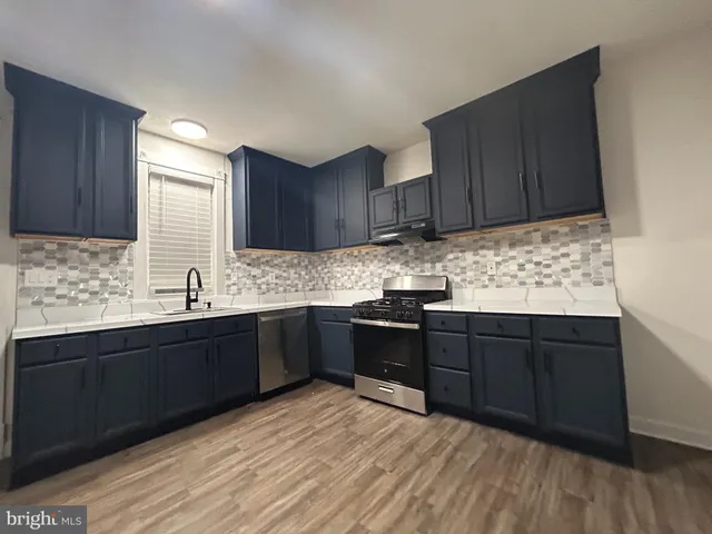 a kitchen with granite countertop wooden cabinets a stove top oven and granite counter space