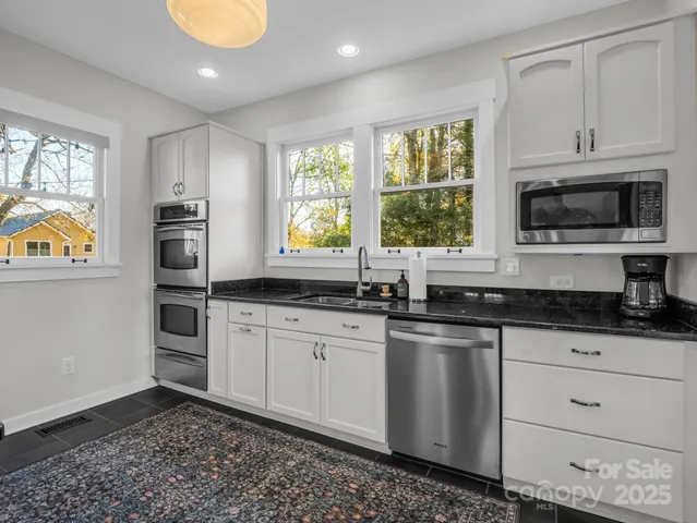 a kitchen with stainless steel appliances granite countertop a stove a sink and a refrigerator