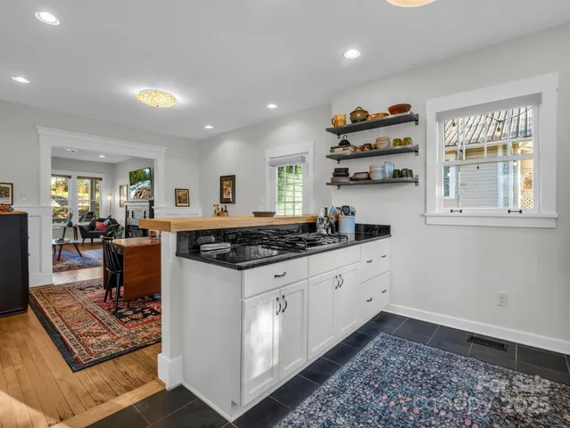 a kitchen with granite countertop a sink a window stainless steel appliances and cabinets