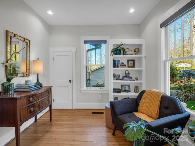 a living room with furniture wooden floor and a view of bookshelf