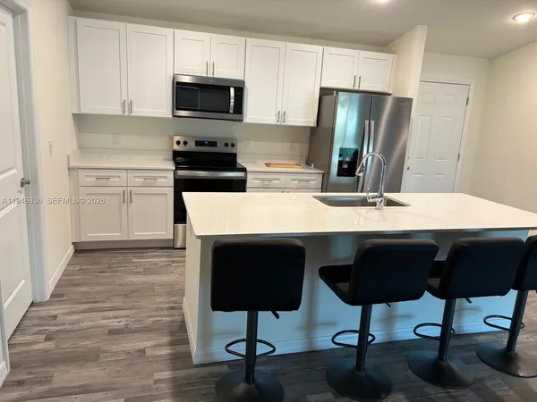 a kitchen with stainless steel appliances granite countertop a refrigerator and a stove top oven