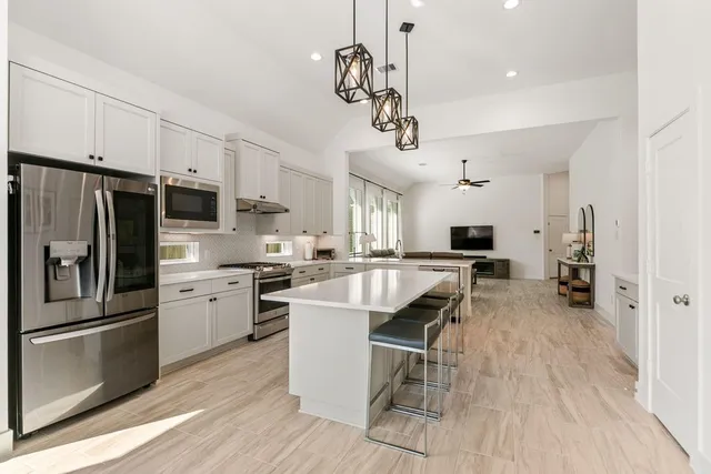 a kitchen that has a lot of cabinets a sink and appliances