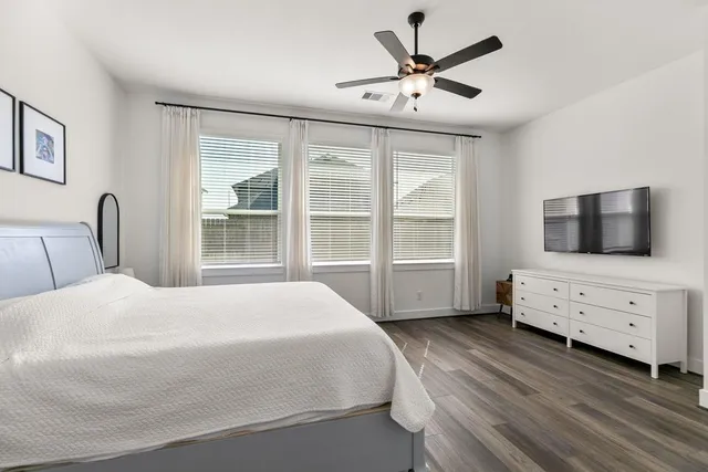 a bedroom with a bed a window and a flat screen tv