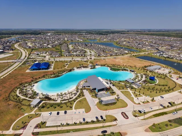 an aerial view of a swimming pool with outdoor seating