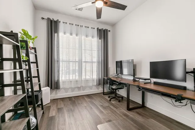a view of a livingroom with workspace and a window