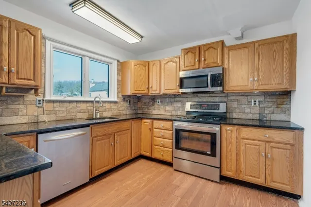 a kitchen with stainless steel appliances granite countertop wooden cabinets a sink and a stove