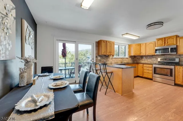 a kitchen with stainless steel appliances granite countertop a stove a sink a dining table and chairs