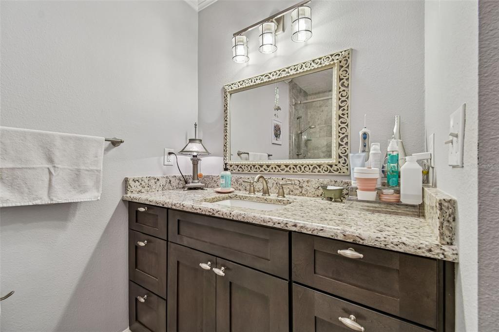 6543 Trail Ridge Drive, Unit 6543 Lakeland, FL 33813 - Photo 32 of 54 a bathroom with a granite countertop sink vanity and a mirror