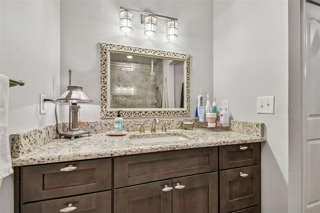 6543 Trail Ridge Drive, Unit 6543 Lakeland, FL 33813 - Photo 33 of 54 a bathroom with a granite countertop sink vanity and a mirror