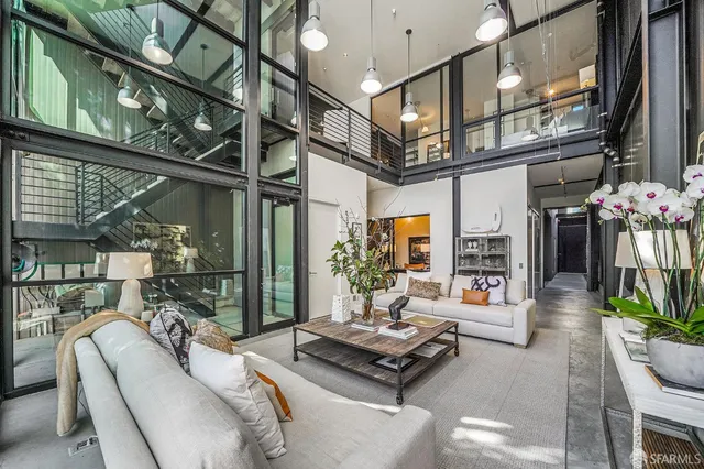 a living room with furniture a chandelier and a floor to ceiling window