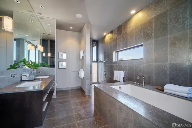a spacious bathroom with a granite countertop sink a toilet a mirror and shower