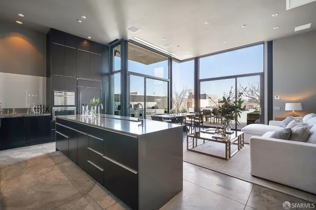a living room with furniture a large window and stainless steel appliances