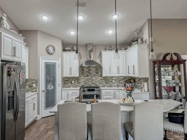 a view of a dining room and livingroom with furniture wooden floor a chandelier