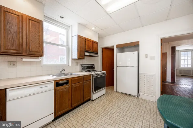 a kitchen with a refrigerator stove top oven and sink