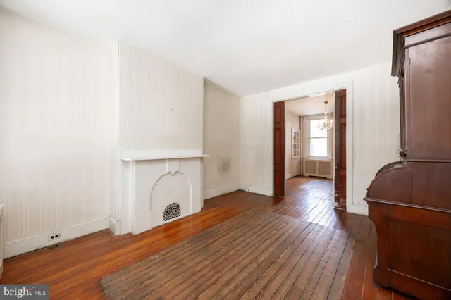 a view of a livingroom with wooden floor and a ceiling fan