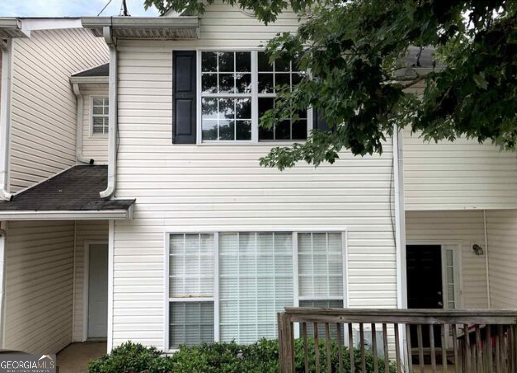 a view of front a house with a plants and trees