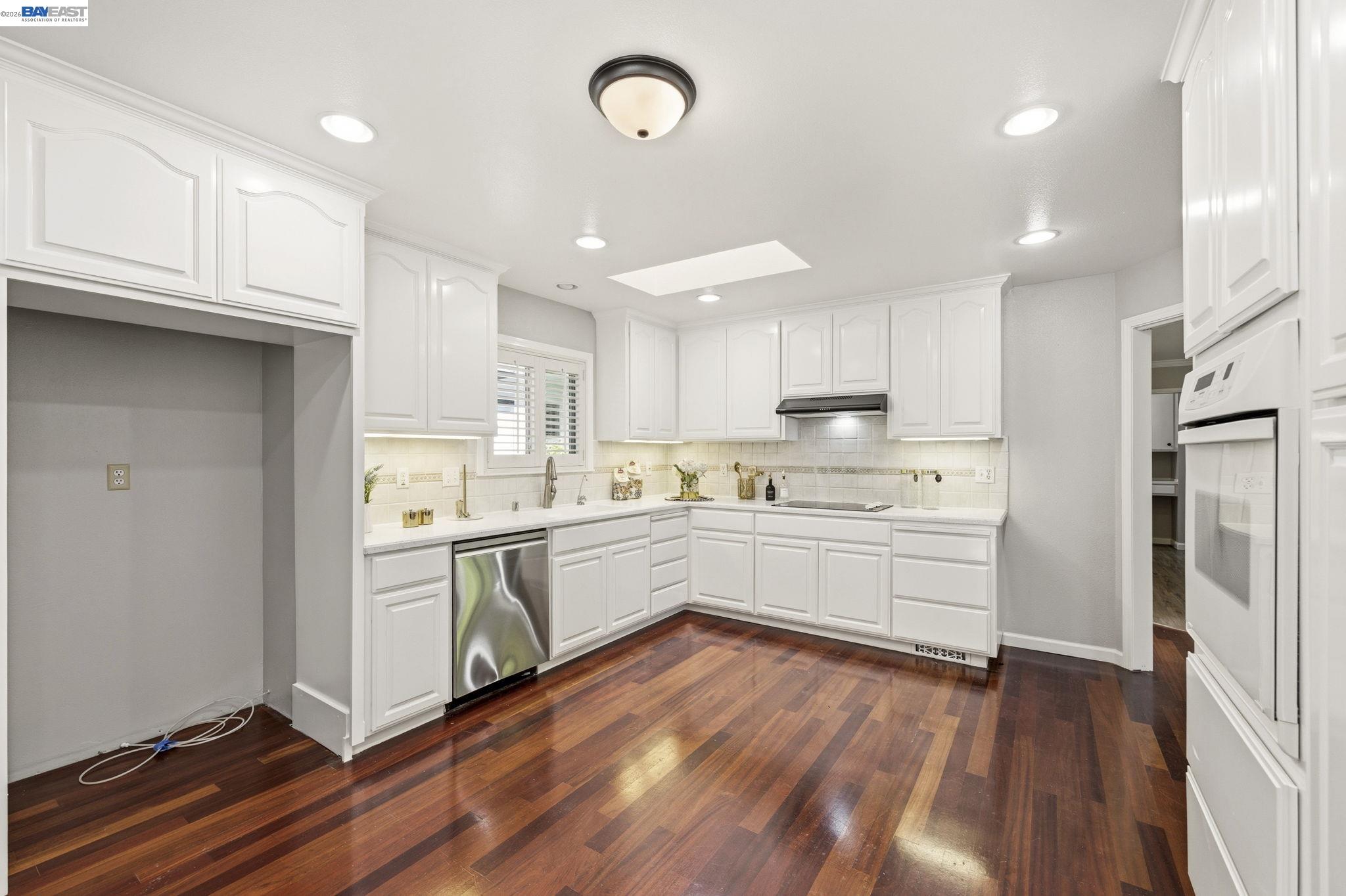4352 Davis Way Livermore, CA 94550 - Photo 11 of 37 a kitchen with granite countertop a refrigerator oven a sink dishwasher and white cabinets with wooden floor