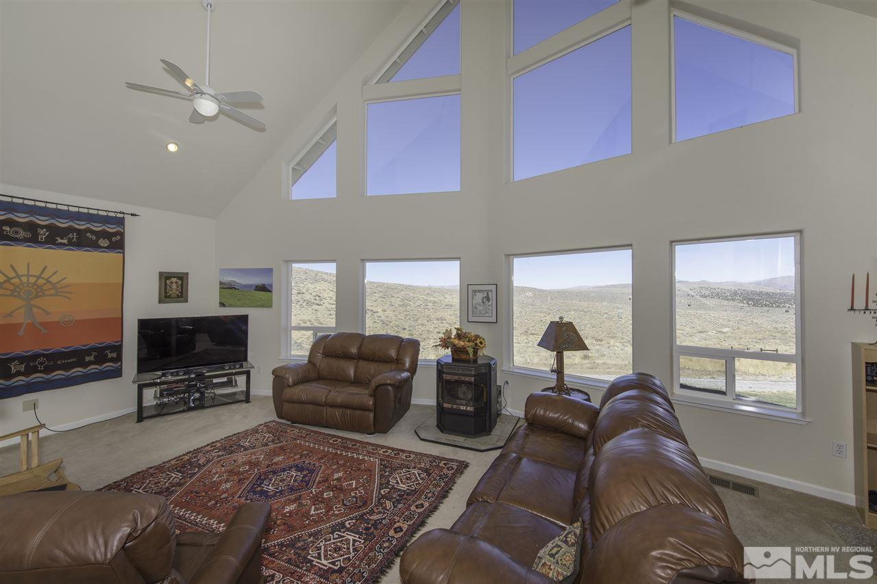 105 John Thomas Lane Reno, NV 89508 - Photo 3 of 25 a living room with furniture a flat screen tv and floor to ceiling window