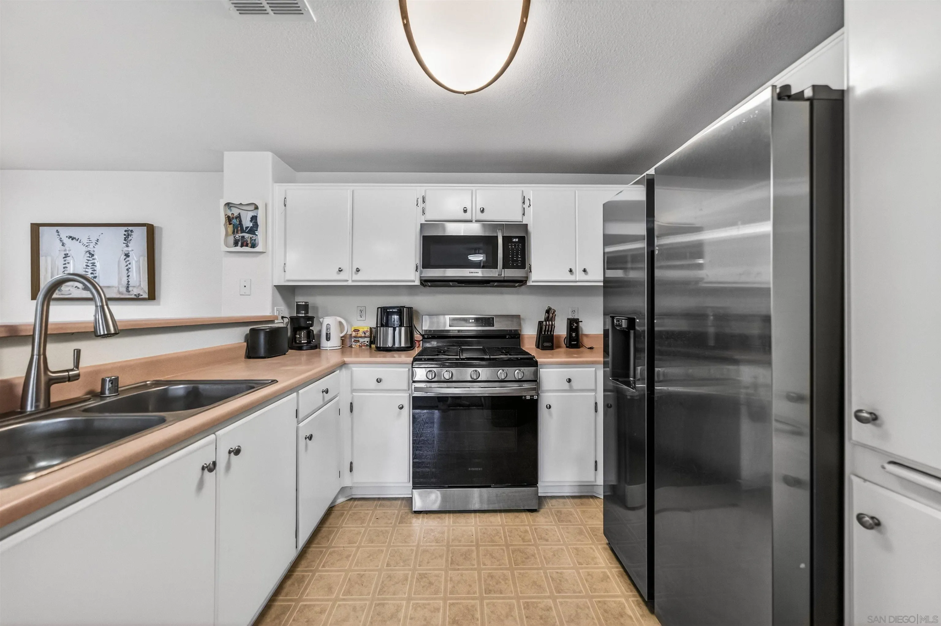 44706 Adam Lane Temecula, CA 92592 - Photo 13 of 36 a kitchen with a refrigerator sink and cabinets