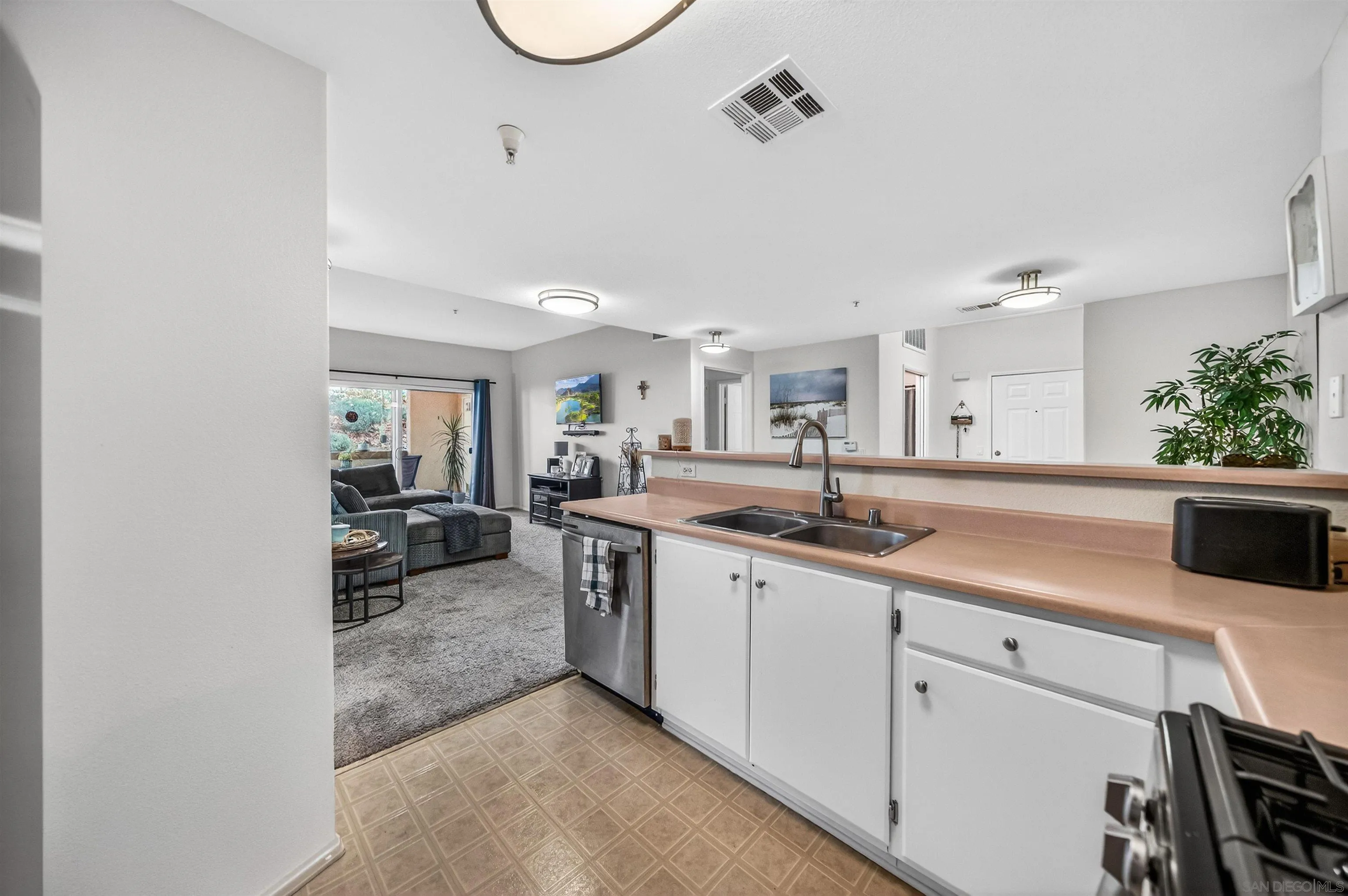 44706 Adam Lane Temecula, CA 92592 - Photo 14 of 36 a large white kitchen with a sink and a stove top oven