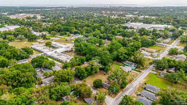 an aerial view of residential houses with outdoor space and trees