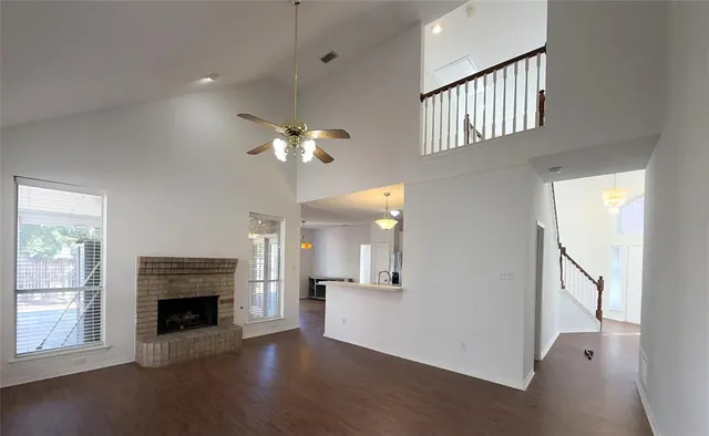 an empty room with windows and fireplace