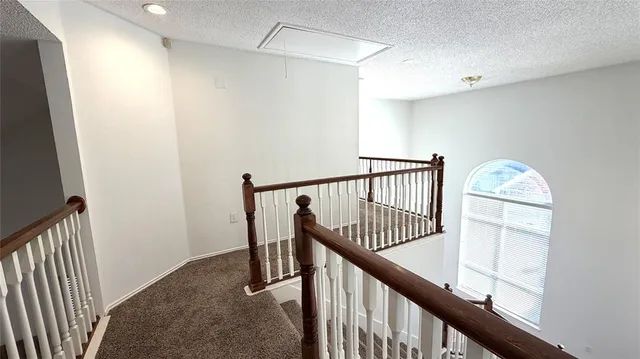 a view of staircase with railing and white walls