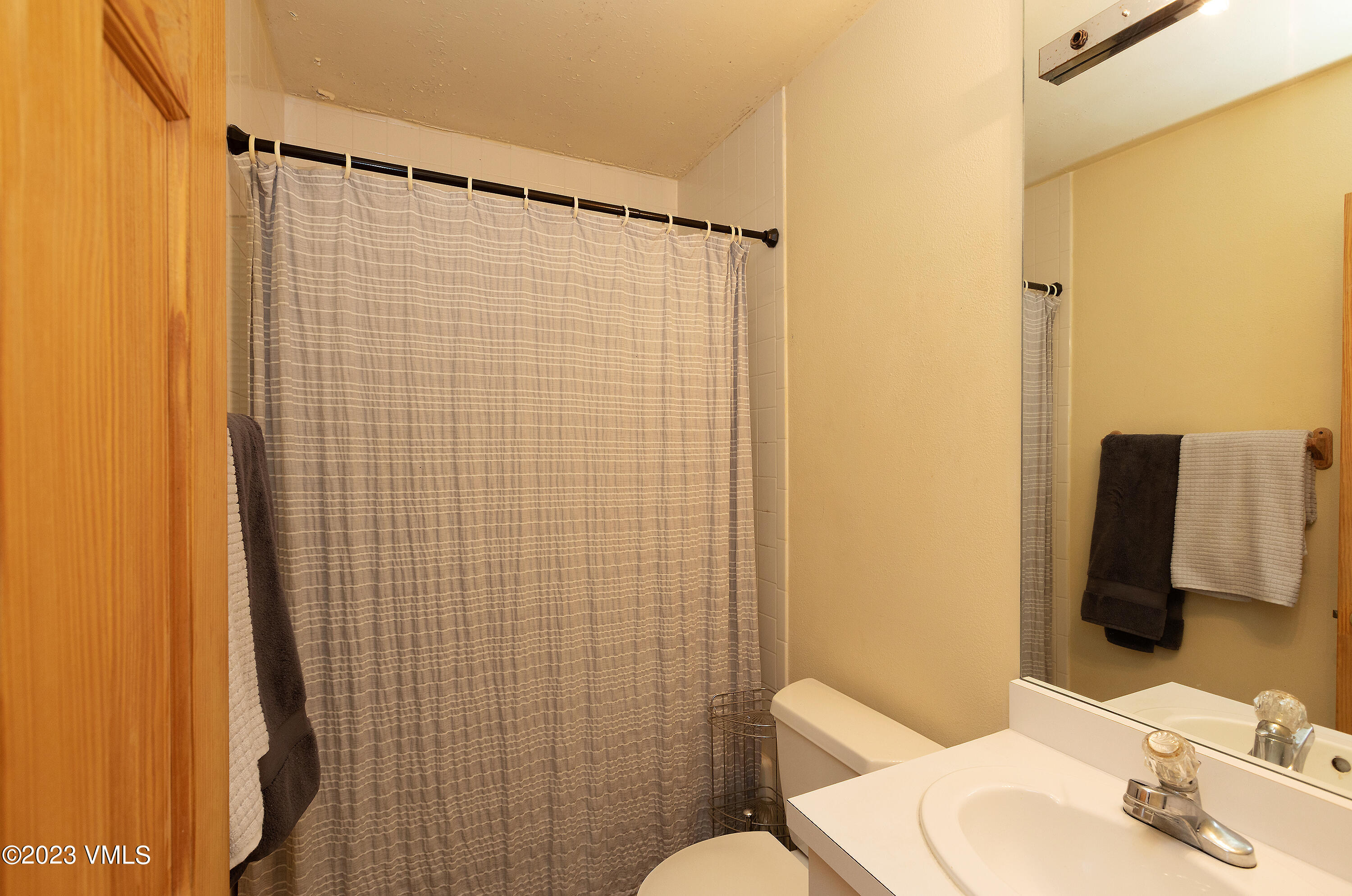 921 Red Sandstone Road, Unit D5 Vail, CO 81657 - Photo 9 of 16 a bathroom with a shower curtain sink and a mirror
