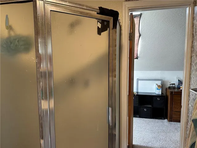 a bathroom with a glass shower door and a bathroom