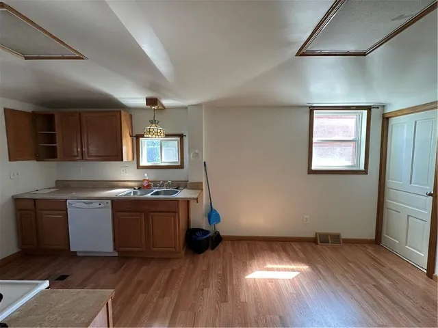 a kitchen with wooden floors and stainless steel appliances