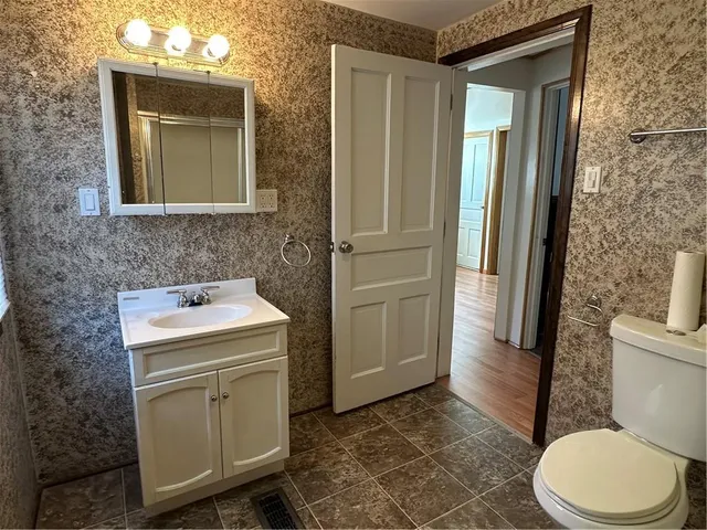 a bathroom with a toilet sink and mirror