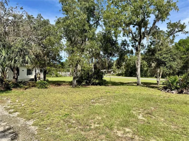 a view of a yard with a house in the background