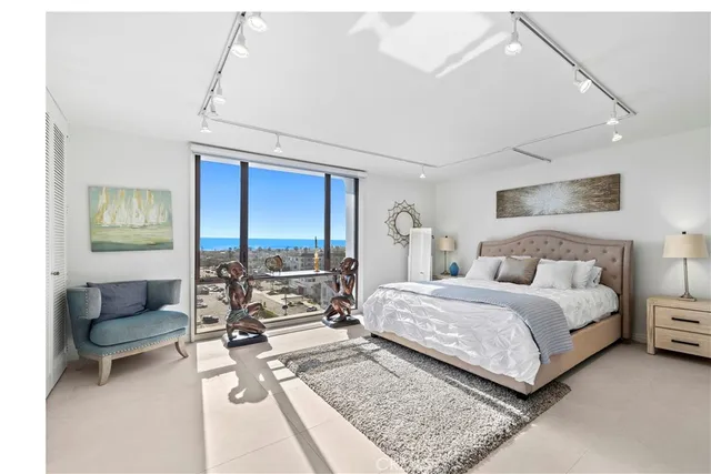 a bedroom with a bed a couch and a potted plant