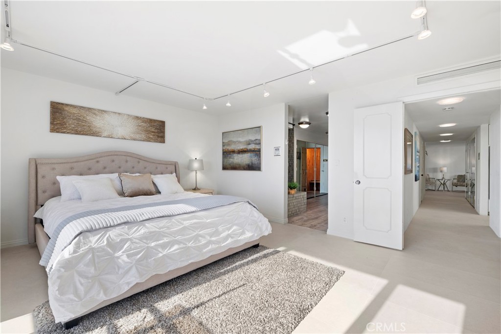 601 Lido Park Drive, Unit 6F Newport Beach, CA 92663 - Photo 14 of 28 a bedroom with a large bed a rug and painting on the wall