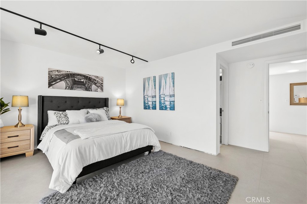 601 Lido Park Drive, Unit 6F Newport Beach, CA 92663 - Photo 17 of 28 a bedroom with a bed and wooden floor