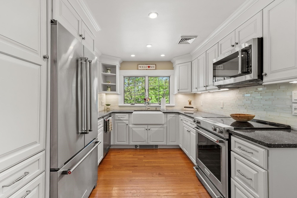 25 Naples Road Melrose, MA 02176 - Photo 10 of 36 a kitchen with stainless steel appliances granite countertop a stove a sink and a microwave