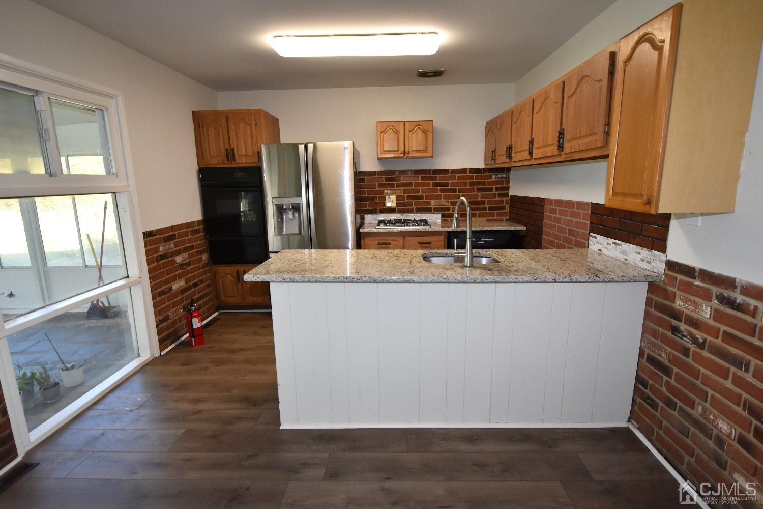 7 Calvin Road Kendall Park, NJ 08824 - Photo 4 of 28 a large kitchen with stainless steel appliances granite countertop a refrigerator a stove a sink and a microwave