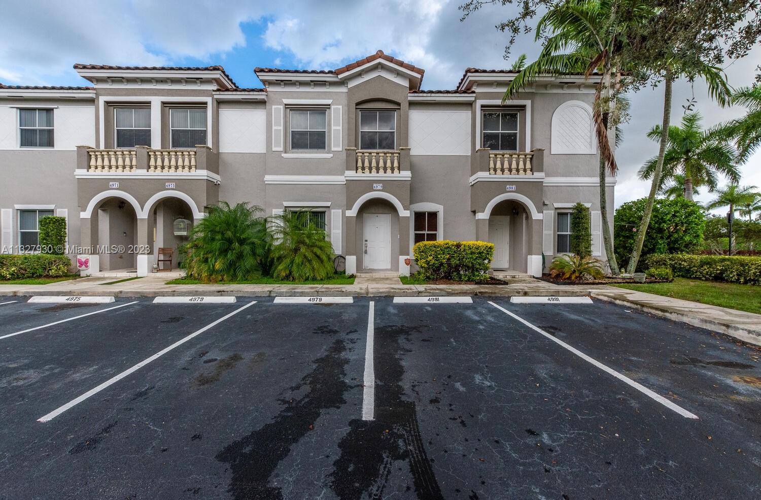4979 Southwest 140th Terrace, Unit 8 Miramar, FL 33027 - Photo 1 of 43 a front view of a house with a yard