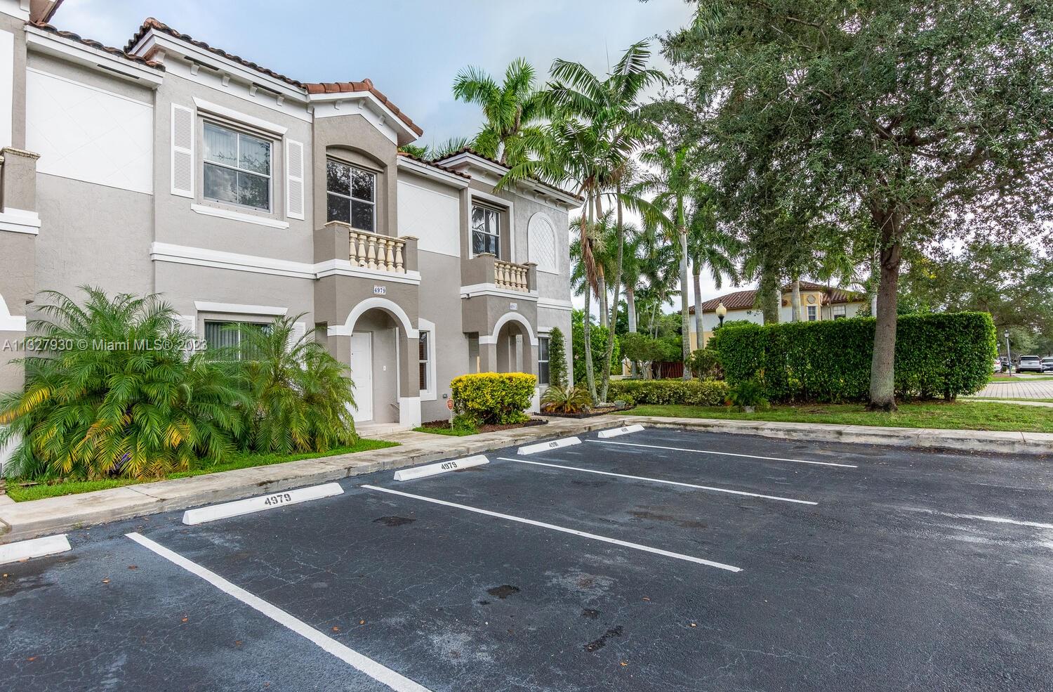 4979 Southwest 140th Terrace, Unit 8 Miramar, FL 33027 - Photo 2 of 43 a front view of a house with a yard and a garage