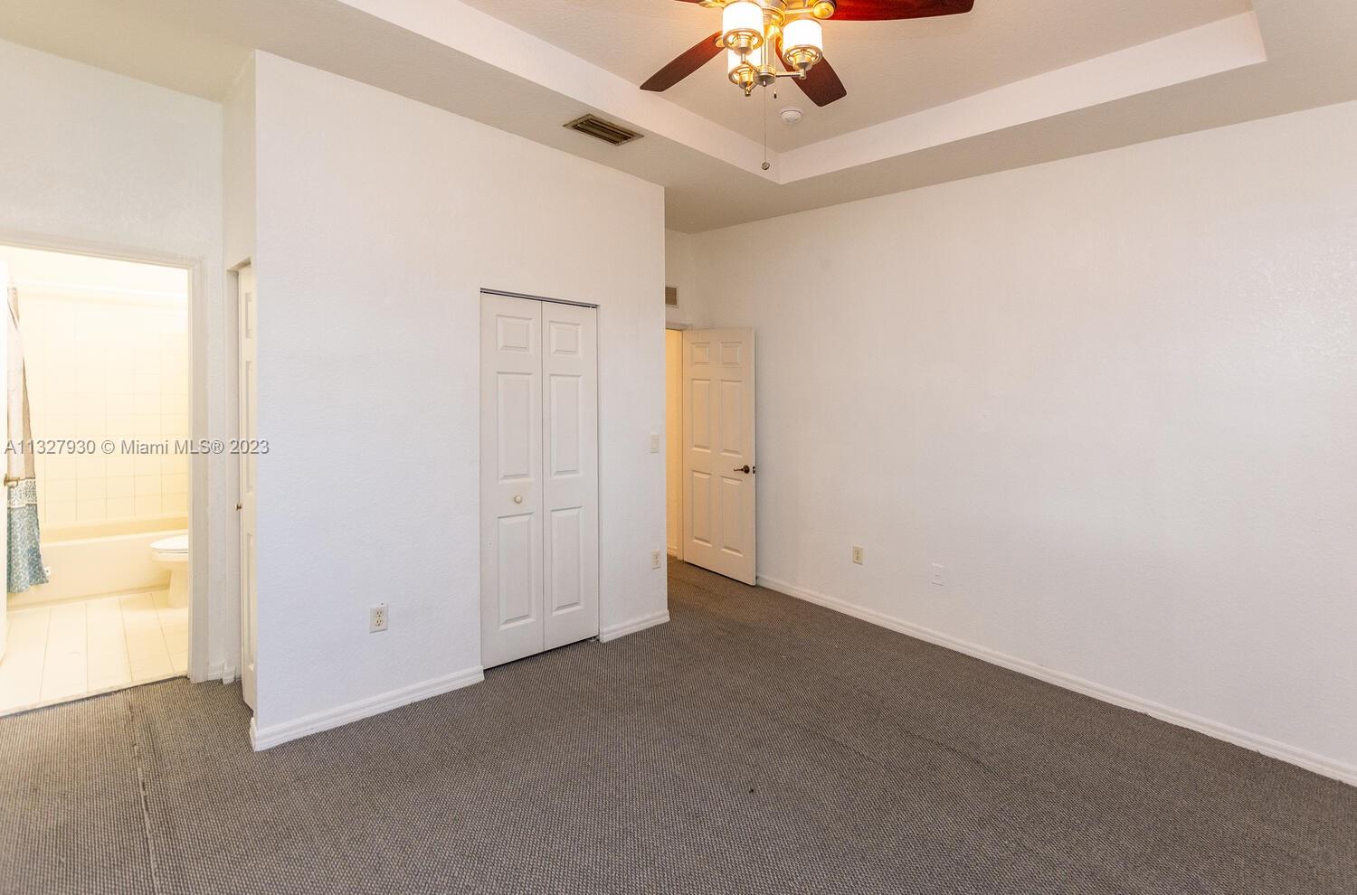 4979 Southwest 140th Terrace, Unit 8 Miramar, FL 33027 - Photo 26 of 43 an empty room with a chandelier fan and windows