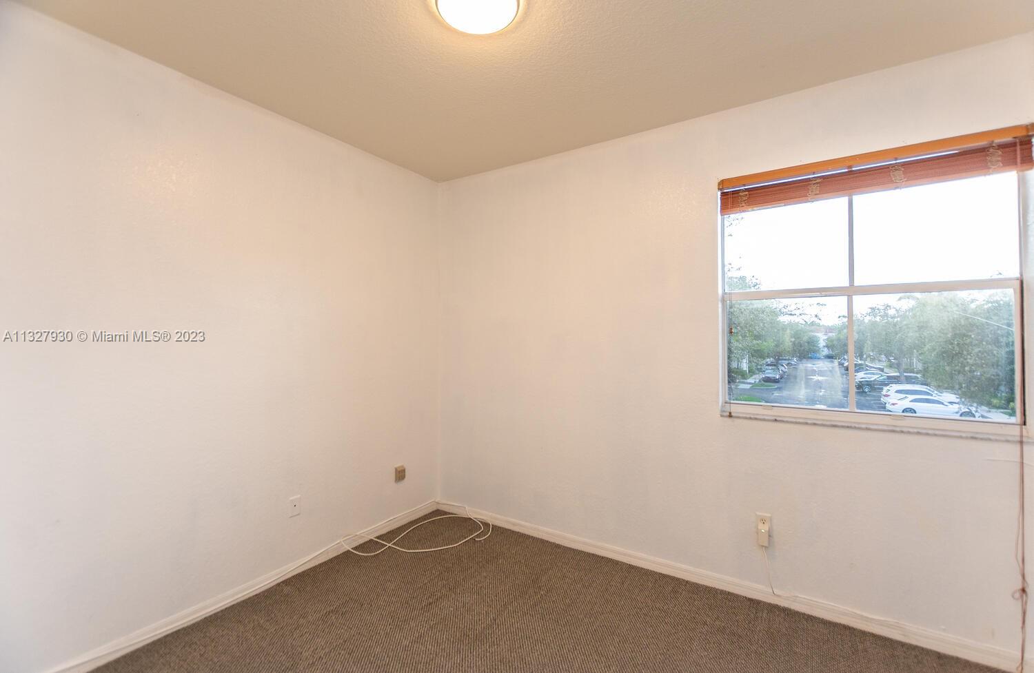 4979 Southwest 140th Terrace, Unit 8 Miramar, FL 33027 - Photo 29 of 43 an empty room with a window