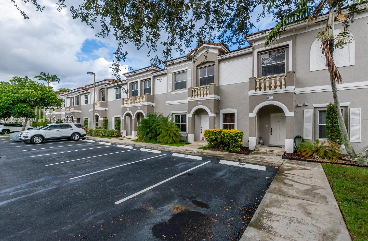 4979 Southwest 140th Terrace, Unit 8 Miramar, FL 33027 - Photo 3 of 43 a front view of a building with cars parked