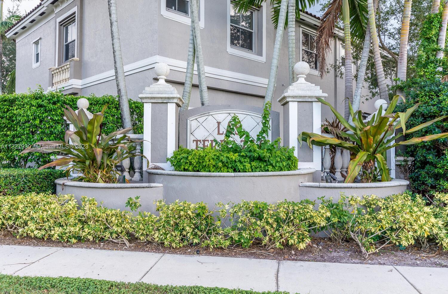 4979 Southwest 140th Terrace, Unit 8 Miramar, FL 33027 - Photo 42 of 43 a front view of a house with a yard and flowers