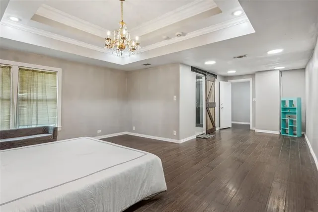 a spacious bedroom with a large bed and a chandelier