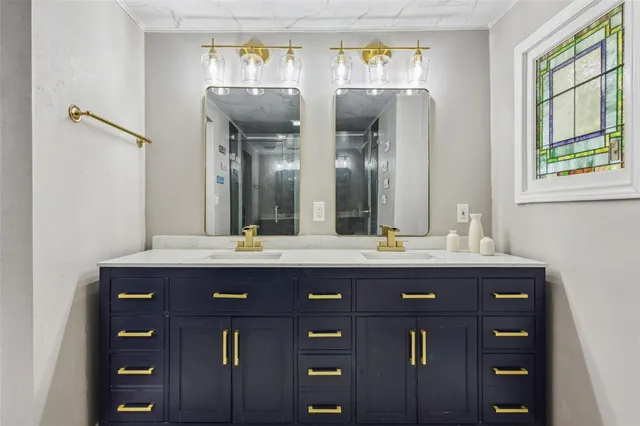 a spacious bathroom with double vanity and a mirror