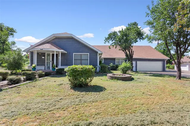 a view of a house with a yard and large tree