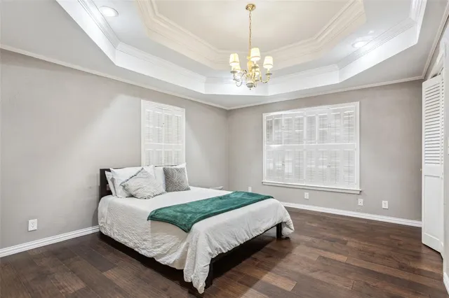 a bedroom with a large bed and a chandelier
